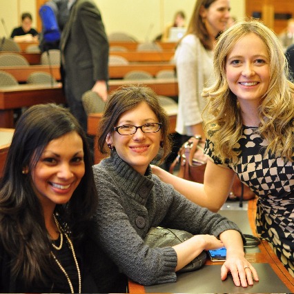 three women smiling facing the camera in a classroom