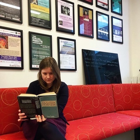 A women reading on a red couch